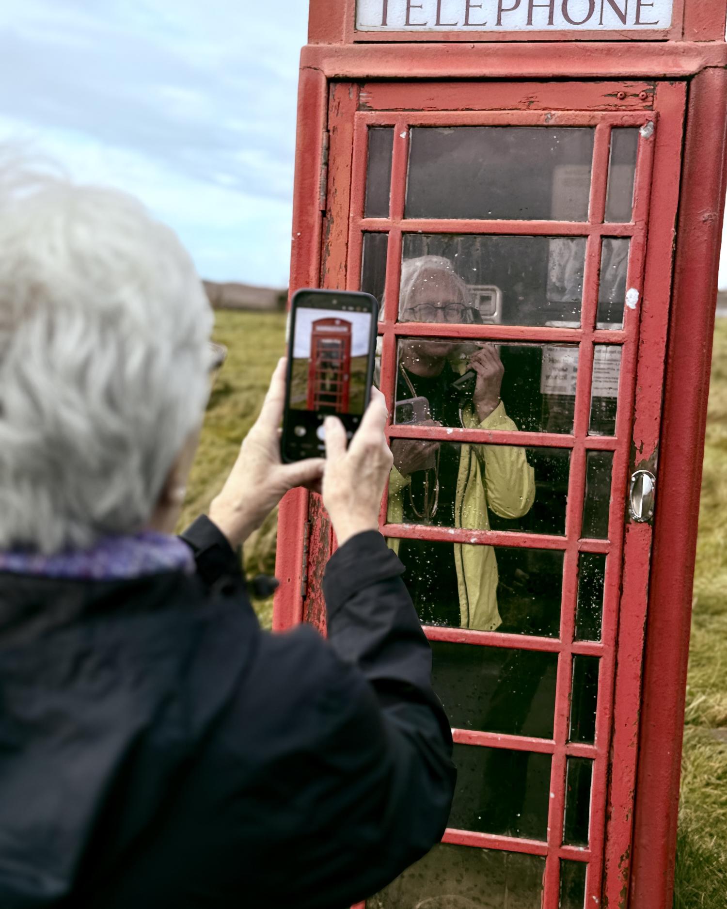 two visitors at red British phone box Isle of Skye